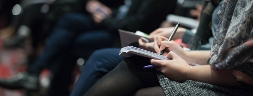 people taking notes in a meeting